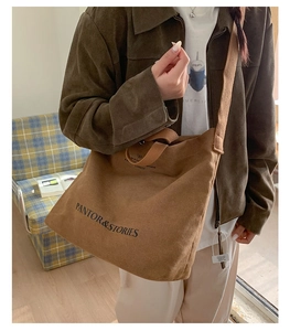 Detail of brown canvas tote bag with adjustable shoulder strap and bow logo print