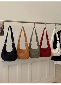 Row of canvas dumpling bags in black, caramel, olive, wine red, and cream white