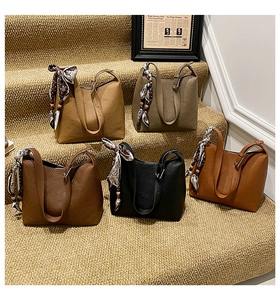 Multiple colors of lychee grain bucket bags with decorative scarves on stairs