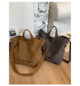 Detailed shot of large canvas tote bags in brown and charcoal with PANTOR brand logo