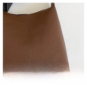 Close-up of premium brown lychee pattern leather texture on stylish bucket bag