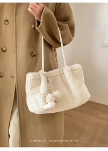Detailansicht der flauschigen weißen Kunstpelz-Tasche mit süßem Stiefel-Anhänger