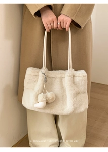 Detail der flauschigen Kunstfell-Tasche mit Stiefel-Anhänger und langen Tragegriffen