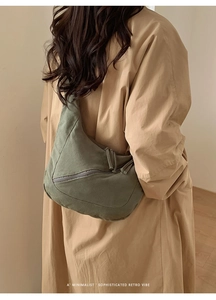Détail du sac bandoulière en toile vert militaire avec poche zippée sur le mannequin