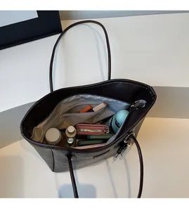 Close-up of deep brown tote bag interior featuring spacious fabric lining and zipper pocket