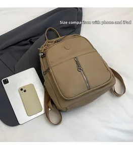 Detaillierter Größenvergleich des khakifarbenen Lederrucksacks mit iPad und Handy