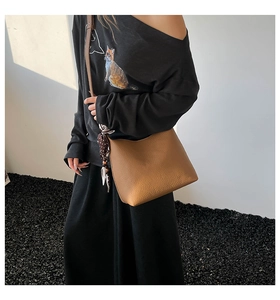 Borsa a secchiello in pelle martellata marrone con foulard a pois indossata dal modello