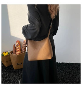 Detail of caramel lychee grain leather crossbody bag showing rich texture and adjustable strap
