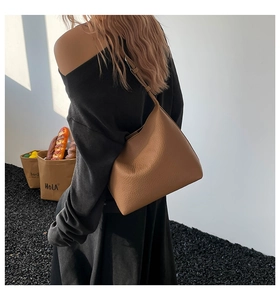 Detailed view of the brown lychee pattern leather shoulder bag with adjustable strap