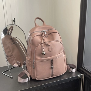 Makro-Detail des altrosa Kunstleder-Rucksacks mit feiner Narbung und Logo-Plakette