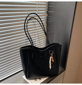 Détail du sac cabas noir avec patch FASHION et pendentif bohème en perles sur la anse