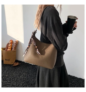 Detail of dark brown pebble leather bag with floral silk scarf on shoulder strap