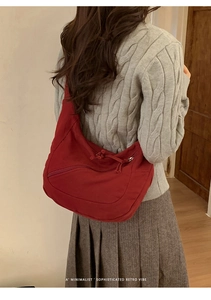 Detailed back view of a minimalist dark red canvas hobo bag with a wide shoulder strap