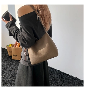 Dettaglio borsa a secchiello in pelle martellata color talpa con struttura hobo e nappa laterale