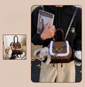 Detail of vintage brown monogram backpack with white faux fur trim and plush pendant