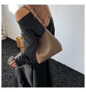 Borsa a spalla in pelle martellata marrone scuro indossata da modella per mostrare trama