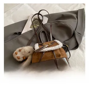 Detail of brown faux leather backpack with plush white trim and cute rabbit charm