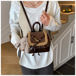 Detail of mini backpack with brown monogram pattern and beige faux shearling trim accents