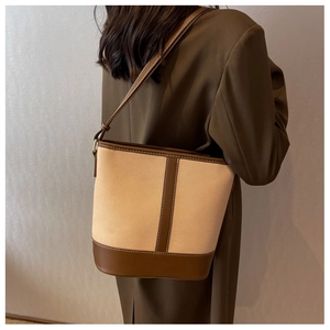 Detail der minimalistischen Beuteltasche aus beigem Canvas und braunen Lederriemen