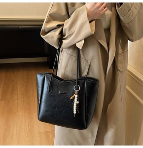 Gros plan sur le sac cabas en cuir noir avec texture plissée et étiquette mode