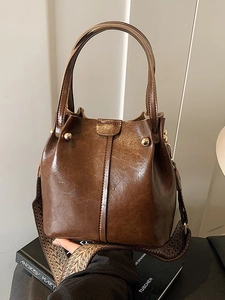 Dark brown textured leather bucket bag with vintage geometric woven wide shoulder strap