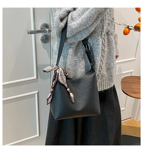 Chic black litchi leather hobo bag styled with a printed scarf and wooden beads
