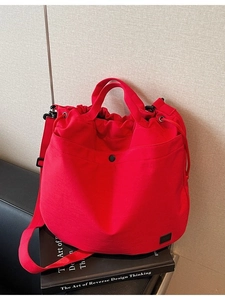 Red canvas drawstring crossbody bag with large capacity and adjustable shoulder strap
