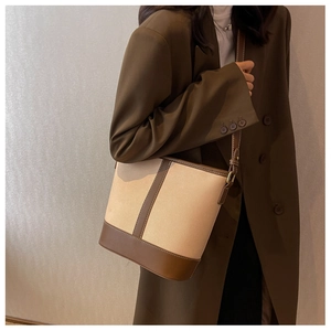 Schicke Beuteltasche aus beigem Canvas mit braunem Lederbesatz an der Schulter
