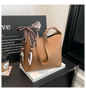 Detail of lychee pattern leather tote with silk scarf and wooden bead decoration