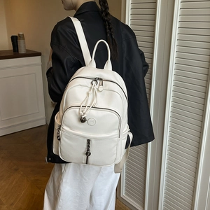 Detailsicht des weißen Rucksacks aus Leder mit Lychee-Maserung und Metallreißverschlüssen