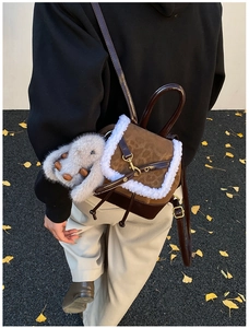 Detail view of a plush patchwork backpack with faux suede texture and cute rabbit charm