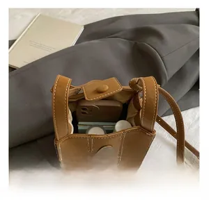 Detailansicht der Eimer-Tasche in Karamell mit Kontrastnähten und Magnetverschluss