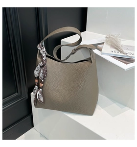 Dettaglio borsa hobo in pelle martellata marrone con foulard in seta e perline di legno