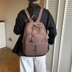 Rückansicht eines Models mit einem morandi-rosa Rucksack aus Leder in Heimatmosphäre