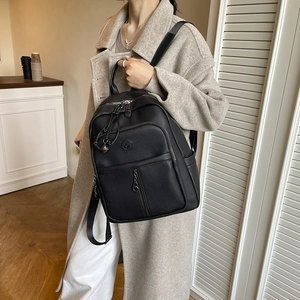 Details des schwarzen Lederrucksacks mit Kieselstruktur und funktionalen Reißverschlüssen