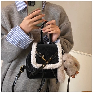 Detail of black leather mini backpack with white faux fur trim and rabbit plush charm