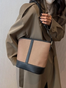 Schicke Canvas-Beuteltasche in Hellbraun mit schwarzem Lederbesatz und weißen Nähten