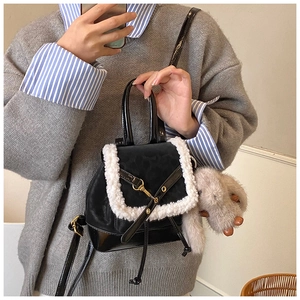 Detail view of the black leather backpack with white faux fur trim and cute bunny charm