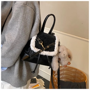 Detail of black leather backpack with white faux fur trim and grey rabbit charm