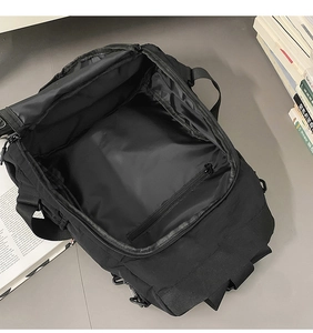 Detail view of the spacious main compartment and internal zip pocket of the black backpack