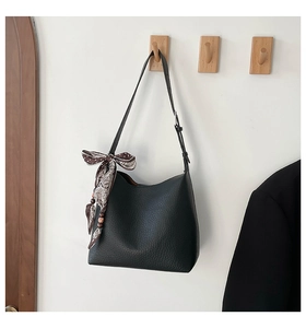 Detail of black lychee grain tote bag with printed silk scarf and wooden beads on hook