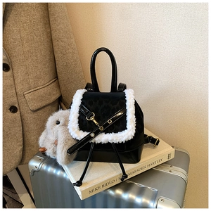 Detail of black leather backpack with leopard print flap and white faux fur trim