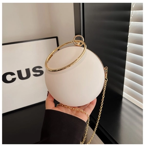 Detail of white spherical acrylic evening bag with gold ring handles and chain strap