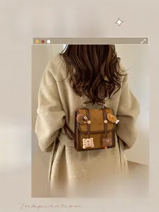 Detail of a brown flap backpack with retro buckles and cute decorative patches on a coat