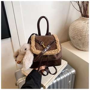 Detail of dark brown vintage mini backpack with plush trim and cute bunny keychain