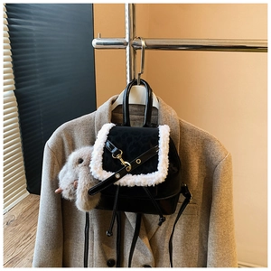 Detail of black mini backpack with leopard print flap and gray bunny charm accessory