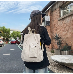 Detailed side view of beige pleated nylon backpack featuring side zipper and snap pocket