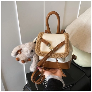 Close-up of vintage faux fur trim and cream leather backpack with plush bunny charm