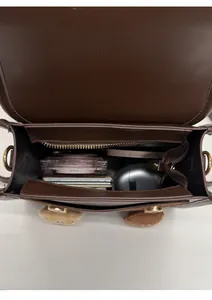 Internal view of brown PU backpack showing spacious compartments and zip pocket