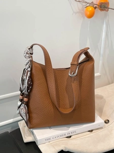 Borsa a secchiello in pelle marrone con foulard stampato e tracolla regolabile